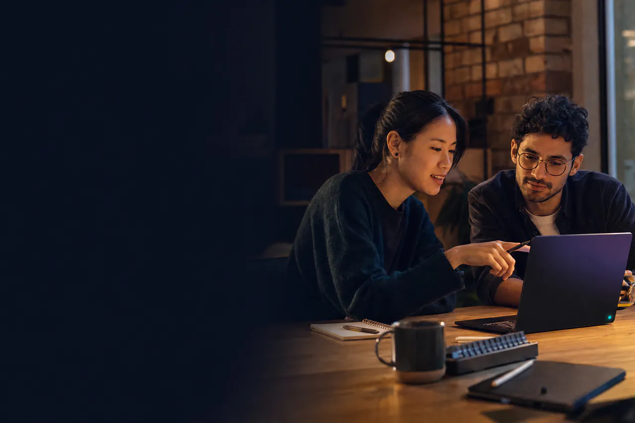Two independent creators reviewing a digital product together on a laptop